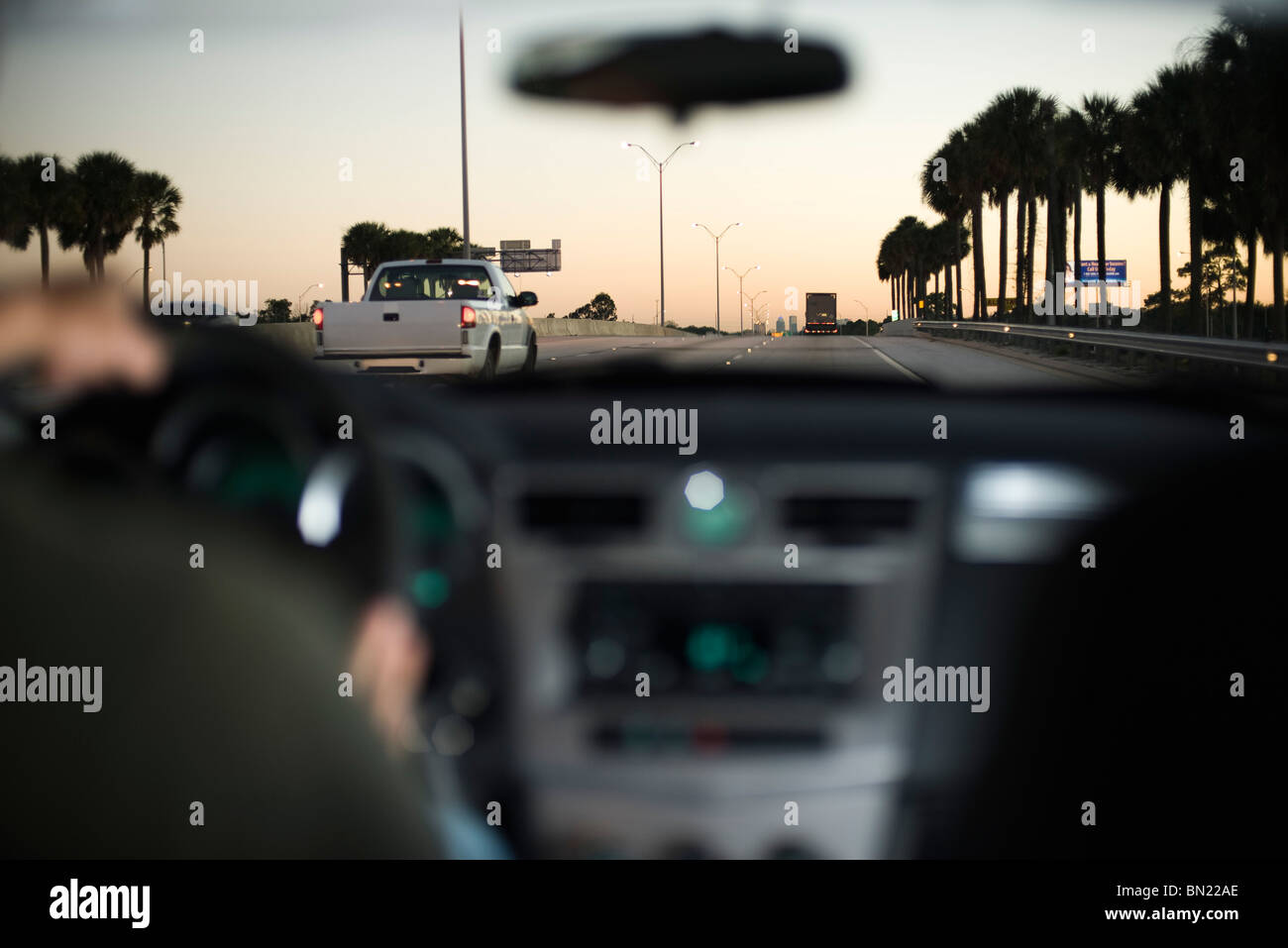 La guida lungo la superstrada in traffico di luce al tramonto Foto Stock
