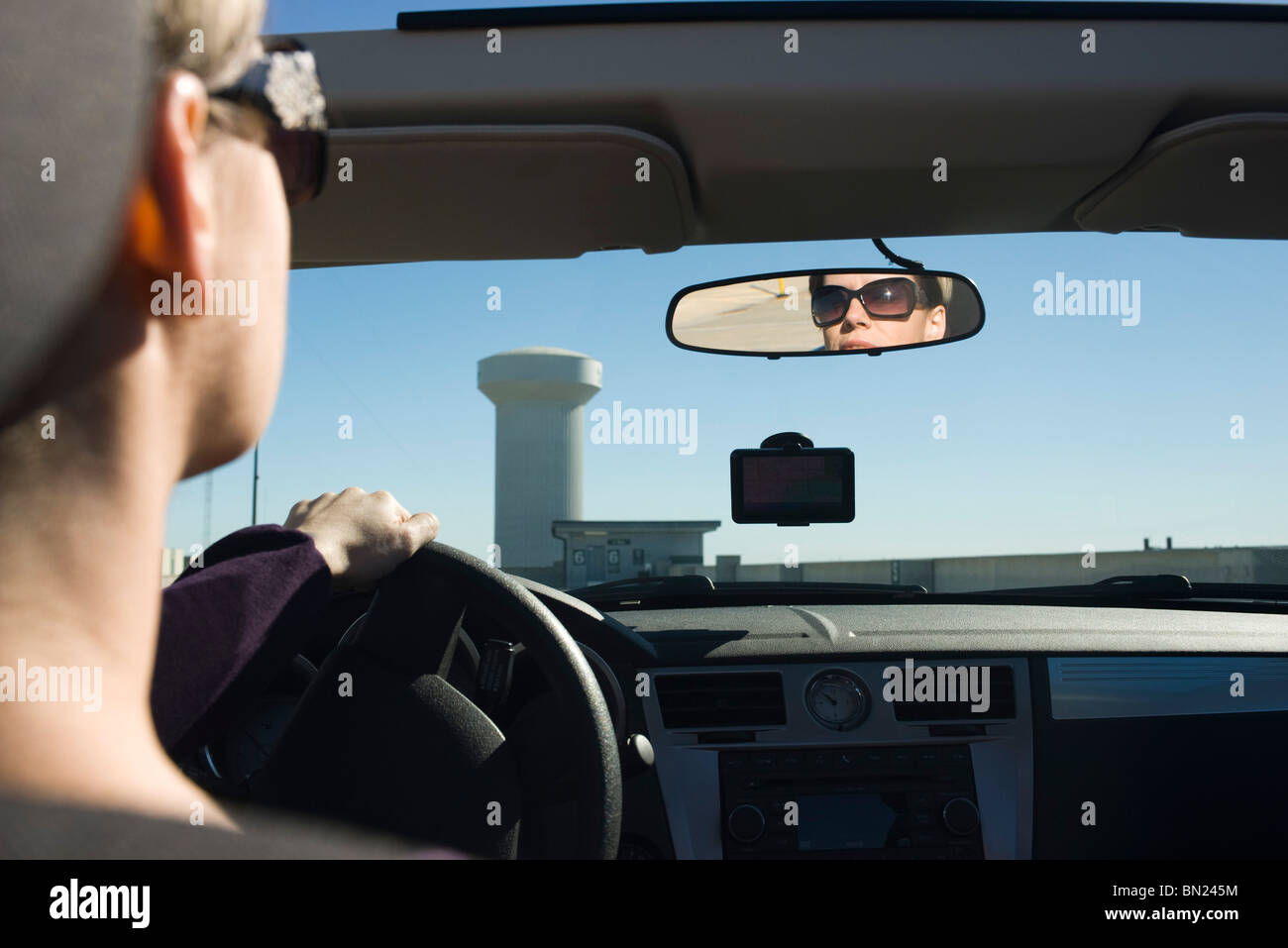 Donna alla guida e la riflessione in specchietto retrovisore Foto Stock