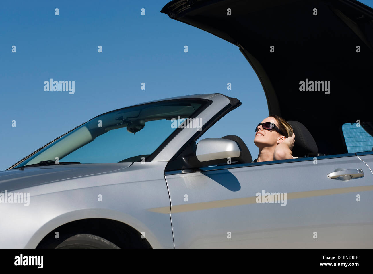 Donna mettendo capote preparando per guidare sul giorno di estate Foto Stock