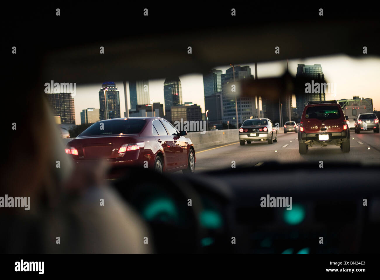La guida nel traffico su autostrada, skyline della città in background Foto Stock