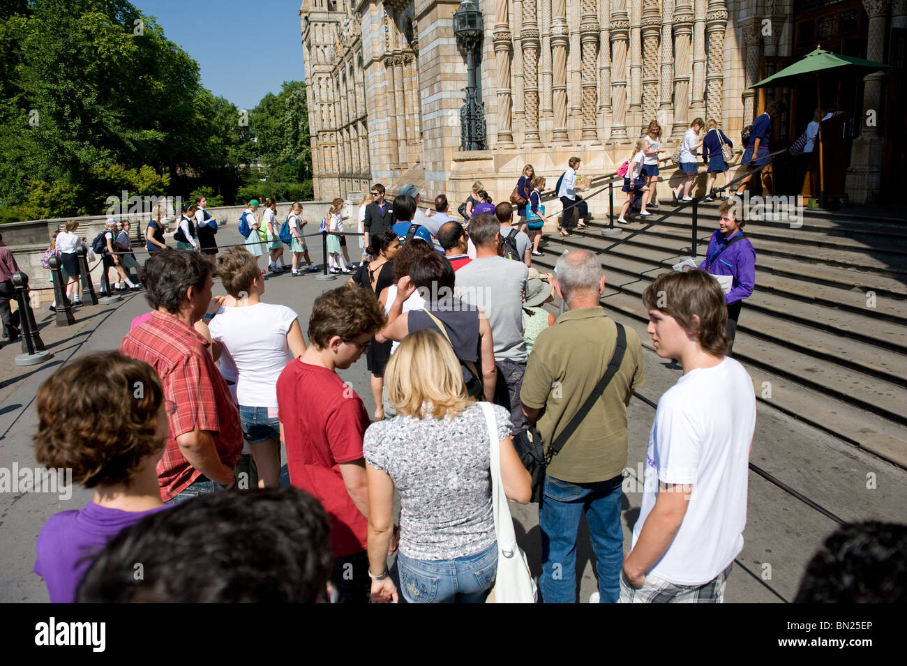 I visitatori in coda fuori l'ingresso per il Museo di Storia Naturale su una mattina d'estate a Londra, Regno Unito Foto Stock