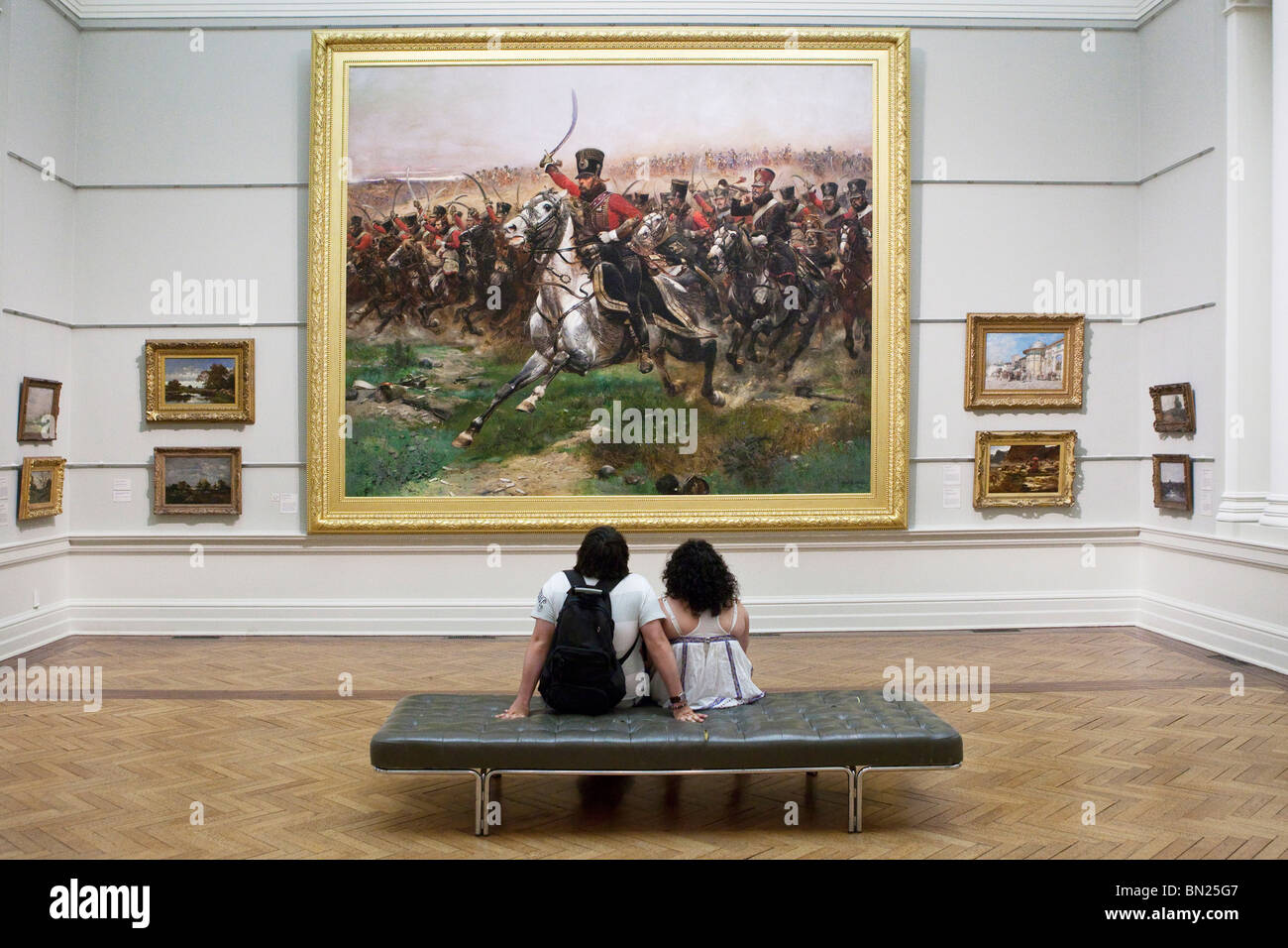 Giovane guardando un grande dipinto in una galleria d'arte Foto Stock