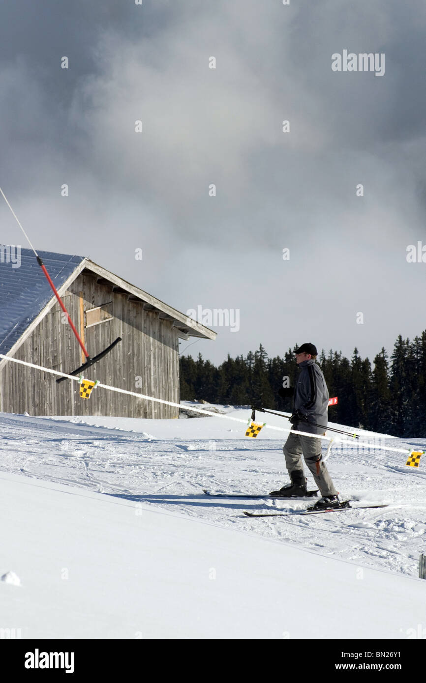 Maschio sciatore maturo lasciando skilift sul pendio a niederhorn alpi svizzere area sci swiss Oberland bernese switzerland travel picture Foto Stock