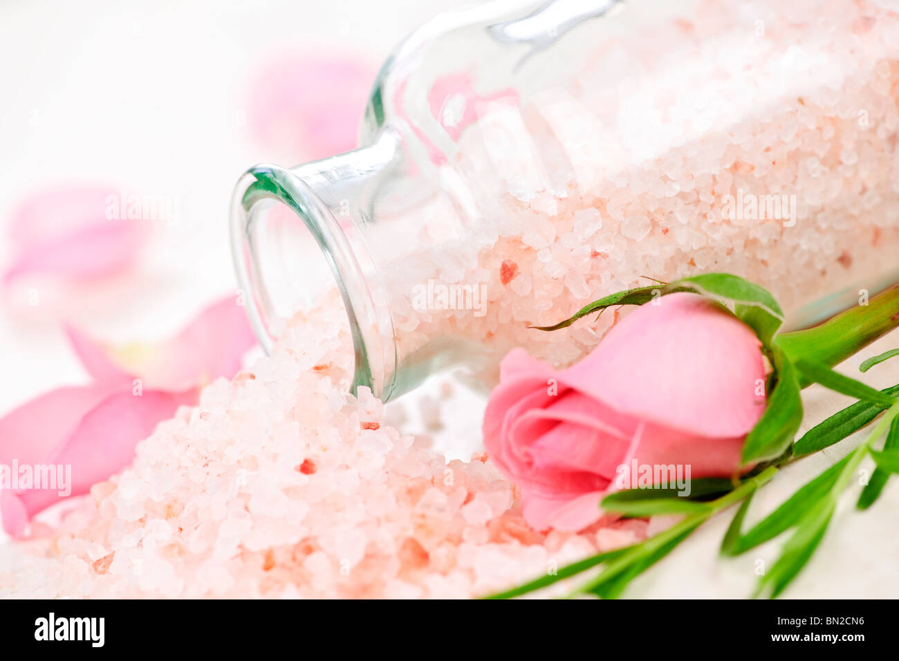 Rosa sali da bagno in un vasetto di vetro con fiori ed erbe Foto Stock