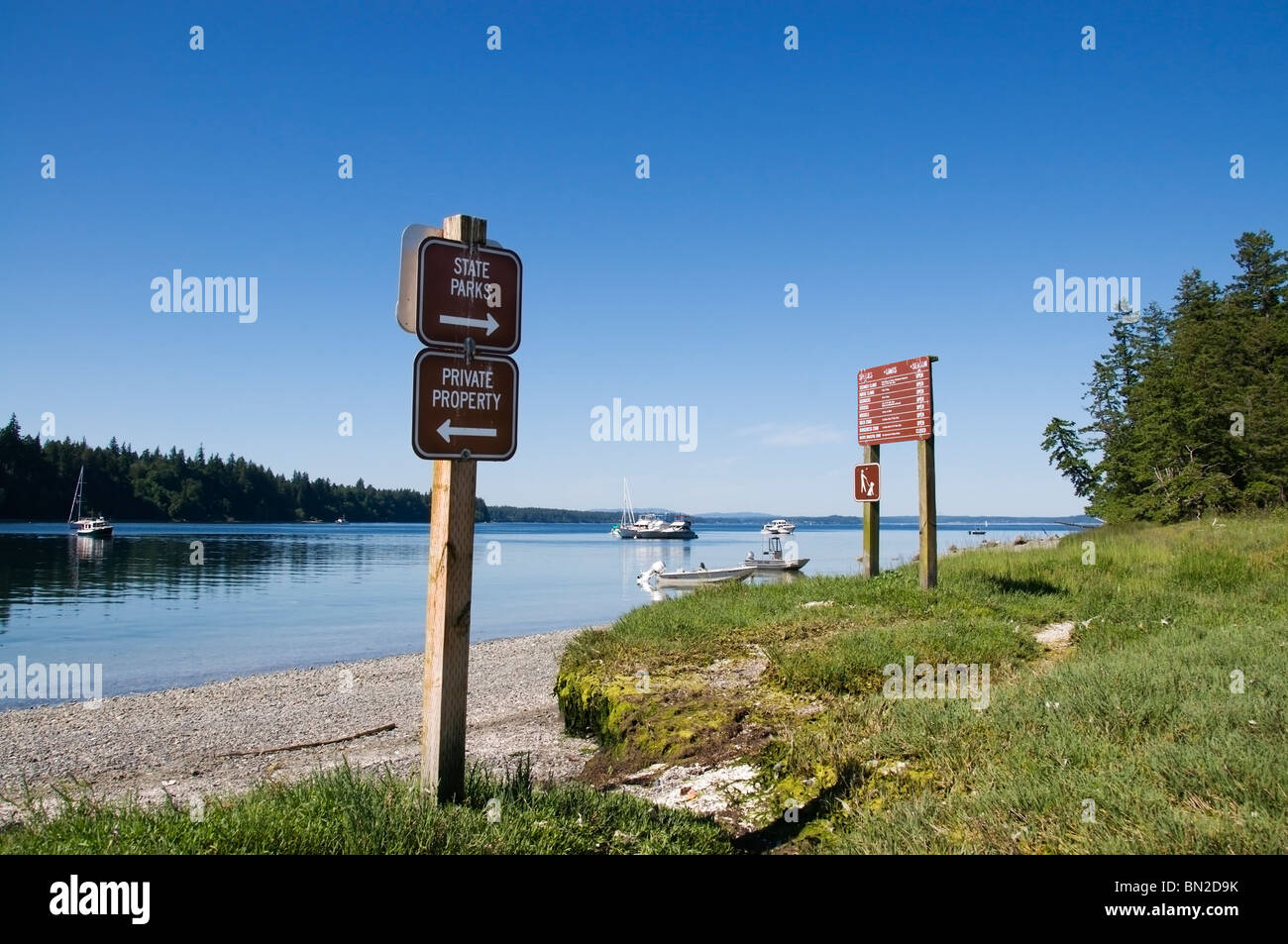 Vista del caso ingresso dalla McMicken Island State Park nel sud di Puget Sound. Segni e il sentiero visibile sulla riva. Foto Stock