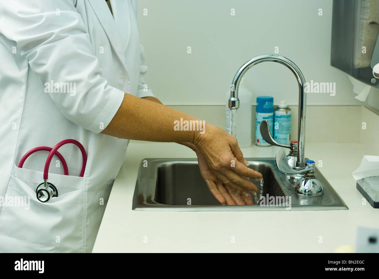 Lavoratore del settore sanitario lavaggio delle mani nell'ufficio del medico Foto Stock
