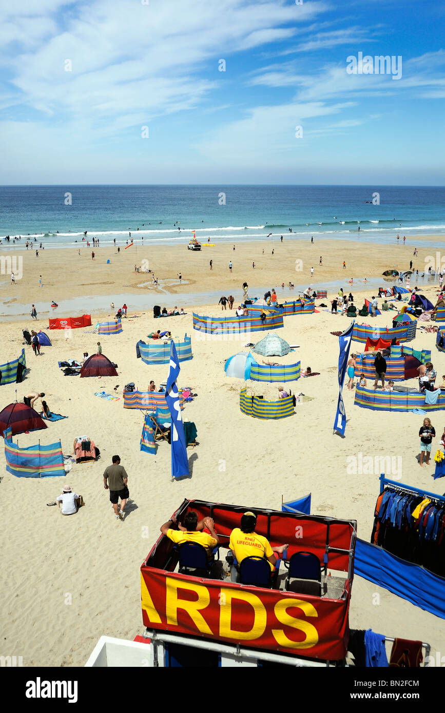 Bagnini si affacciano su una spiaggia di sabbia piena di turisti Foto Stock