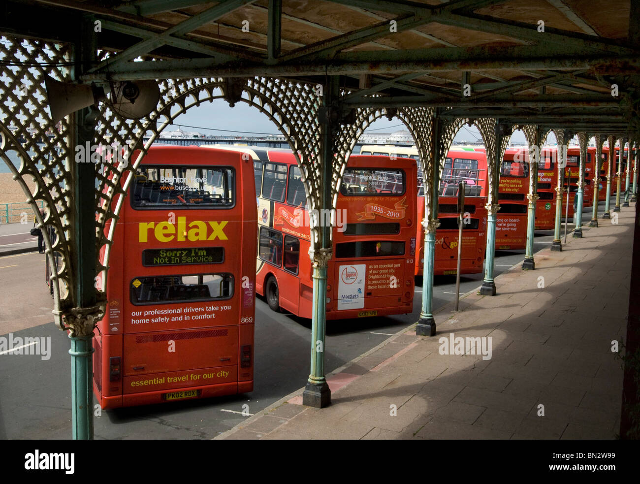 Una fila di Brighton & Hove Autobus e pullman Società Double Decker bus stand sotto le arcate ornate di Madeira Drive, Brighton Foto Stock