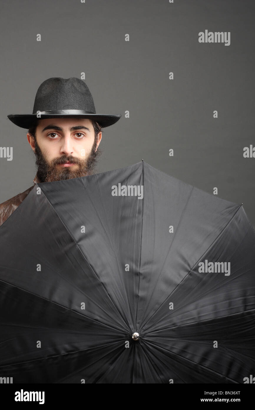 Uomo in hat con la barba e ombrellone Foto Stock
