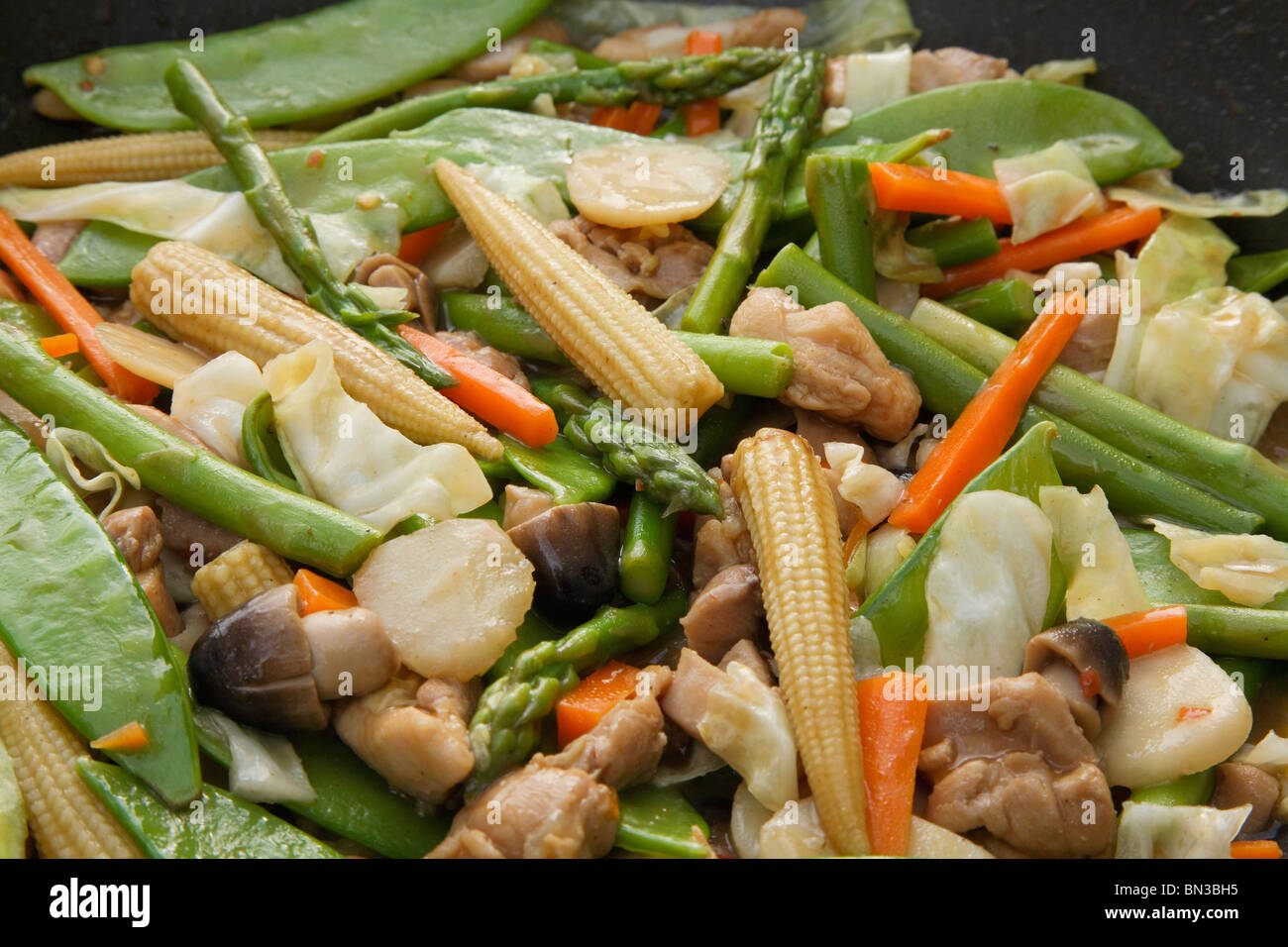 Verdure Cinesi e pollo stir fry nel wok close-up Foto Stock