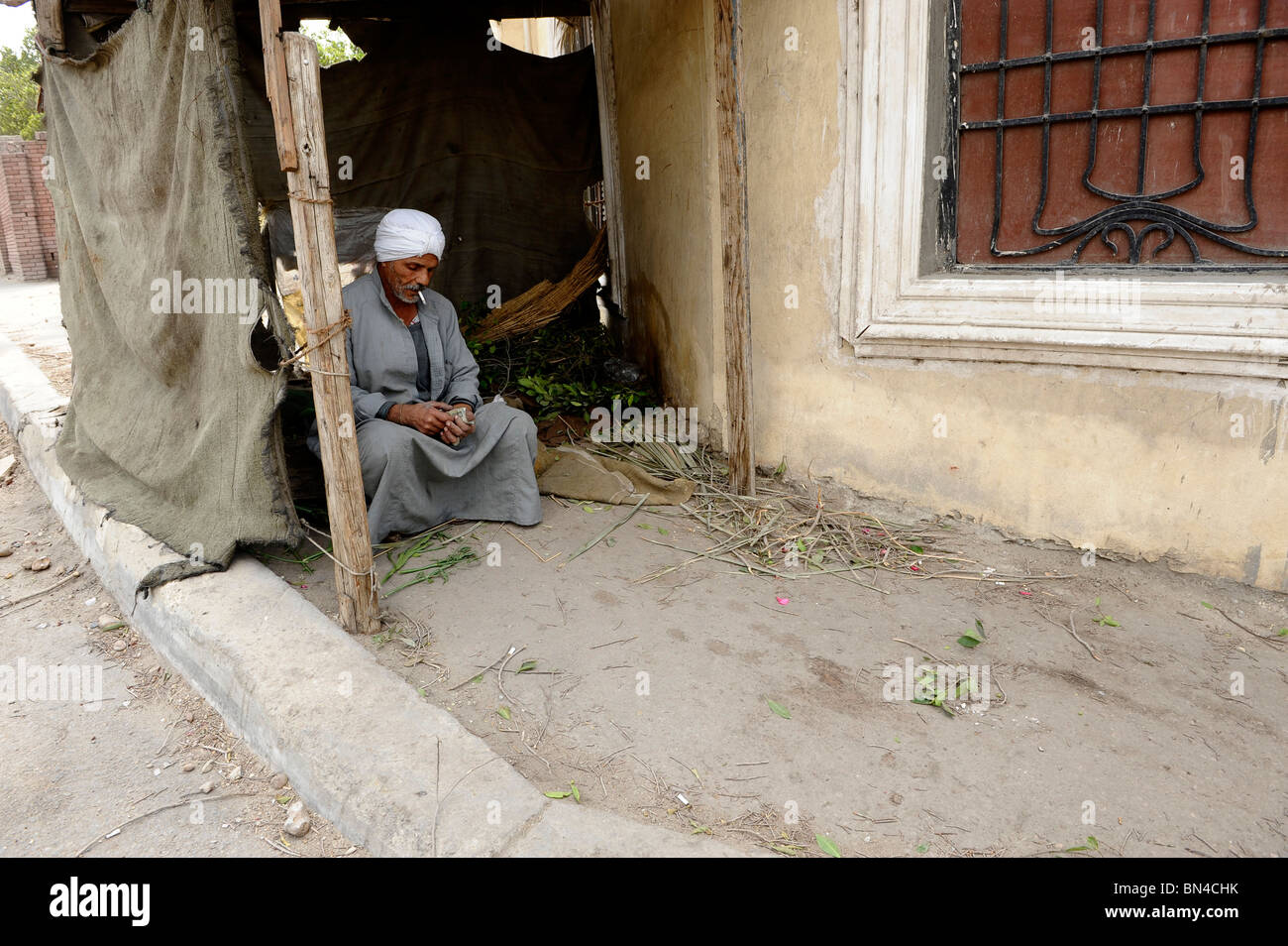 Il vecchio uomo egiziano seduto fuori di casa sua nel Cairo islamico, il Cairo , Egitto Foto Stock