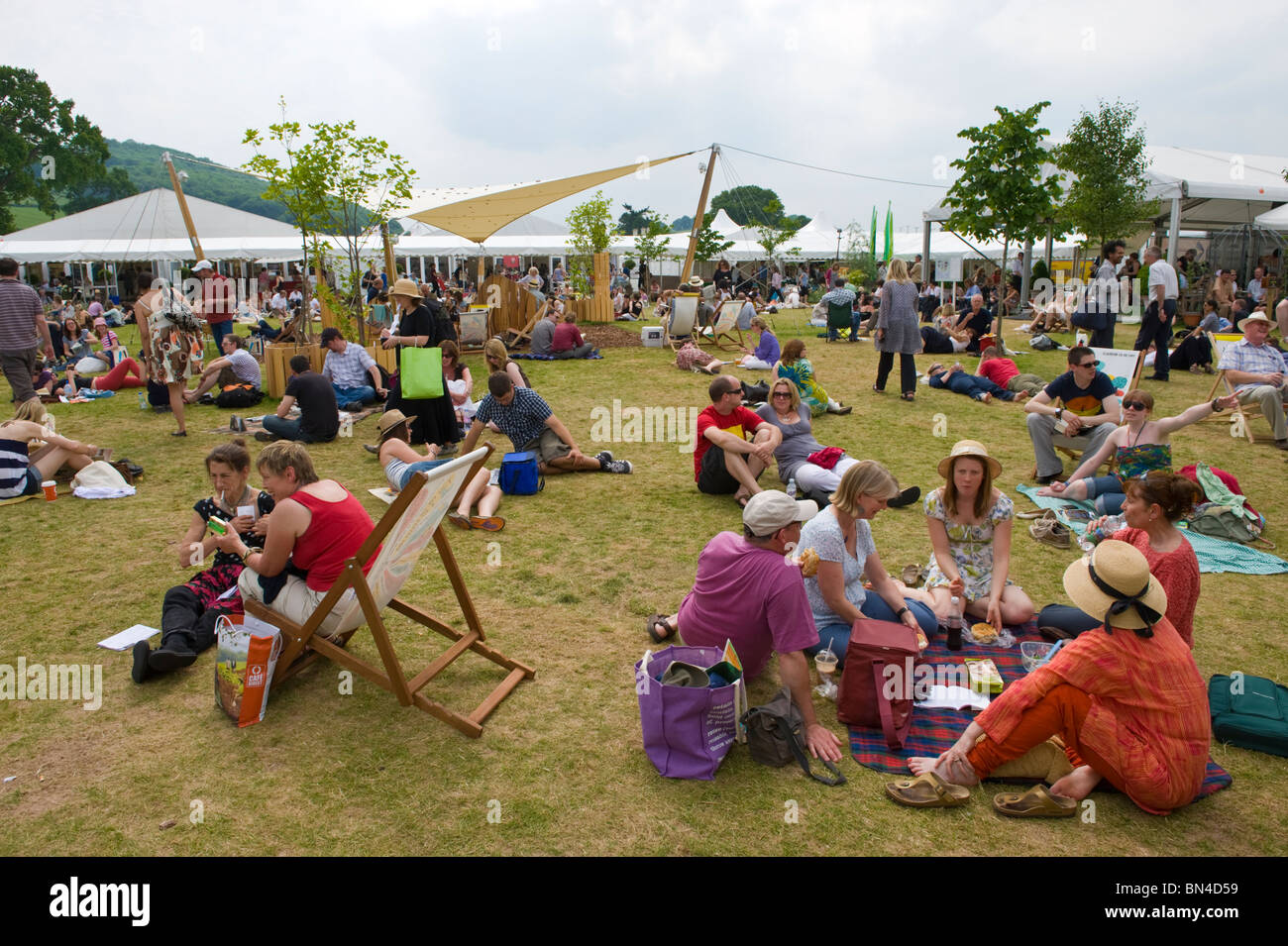 Persone rilassante sull'erba nel sole estivo a Hay Festival 2010 Hay on Wye Powys Wales UK Foto Stock