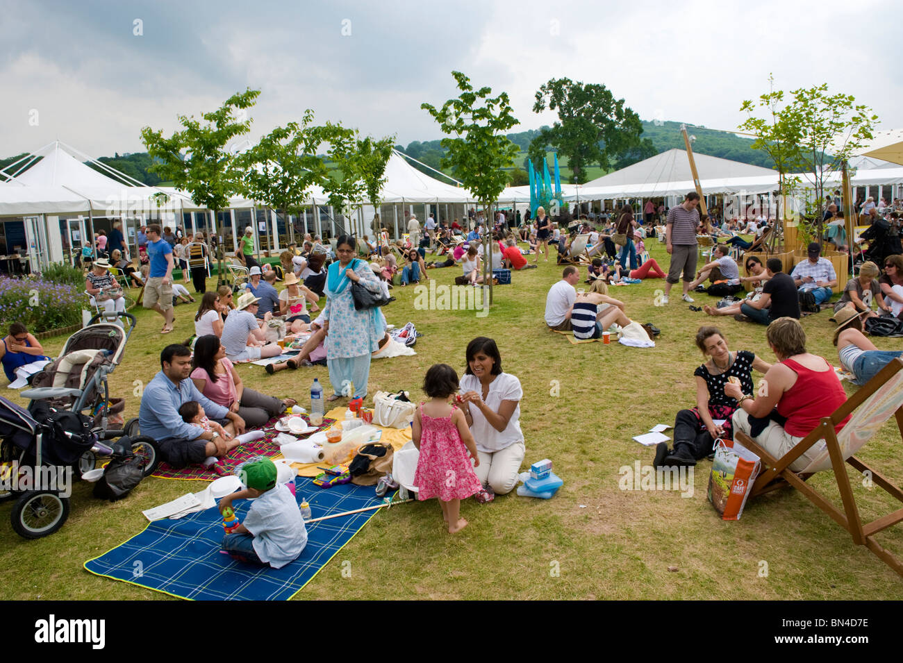 Persone picnicing rilassante sull'erba nel sole estivo a Hay Festival 2010 Hay on Wye Powys Wales UK Foto Stock