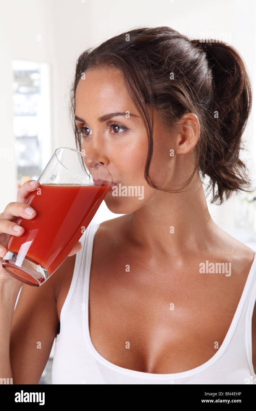 Donna di bere succo di pomodoro Foto Stock