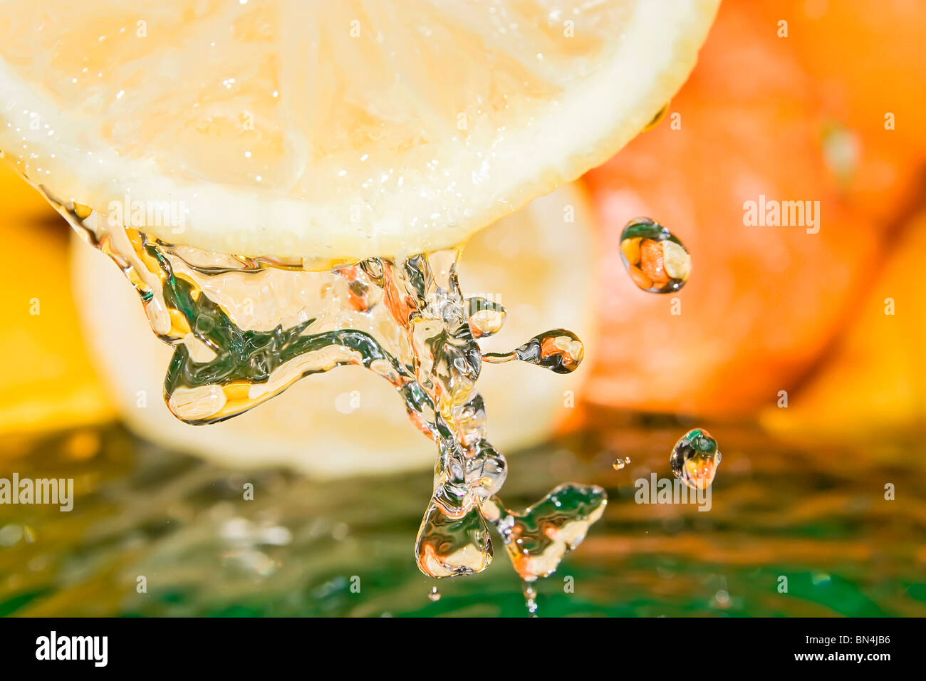 Gocce di succo. Agrumi freschi con acqua corrente.gocce di vitamine. Foto Stock