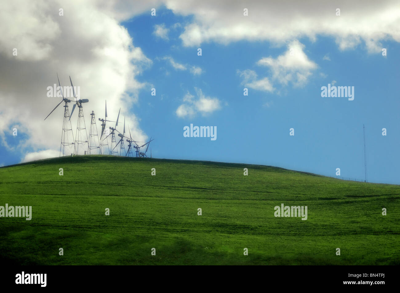 Numerosi mulini a vento sulla collina di erba contro un cielo blu. Trasognata. Foto Stock