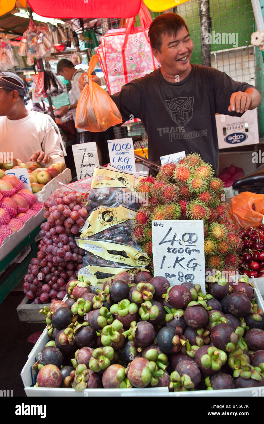 Un venditore ambulante vende mangostani e altri frutti in un asiatico mercato della frutta in Malesia Foto Stock
