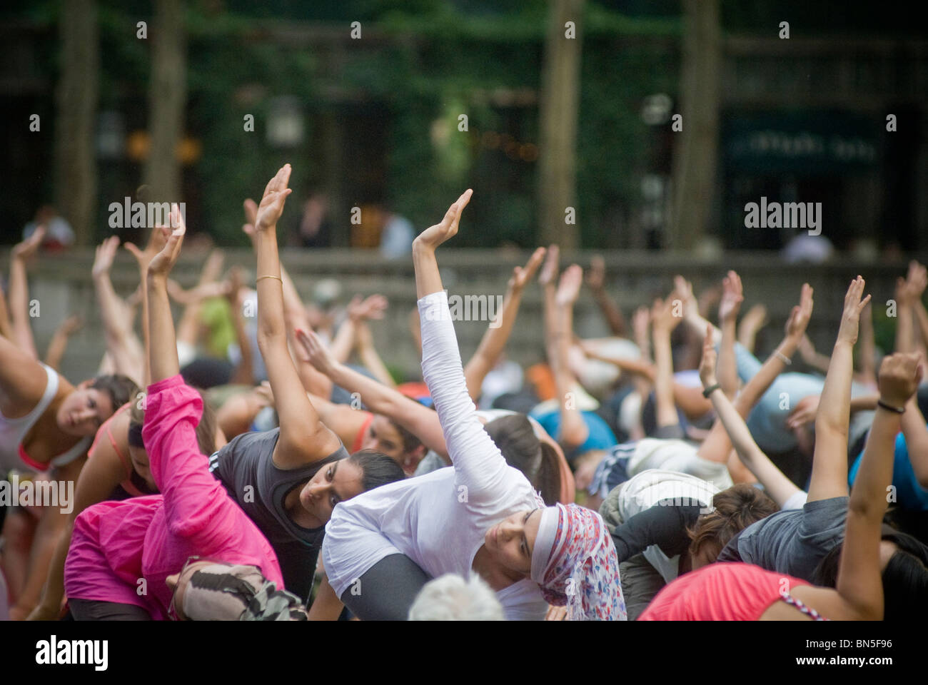 Centinaia di praticanti di yoga di tutti i livelli di partecipare in un libero yoga classe data in Bryant Park di New York Foto Stock