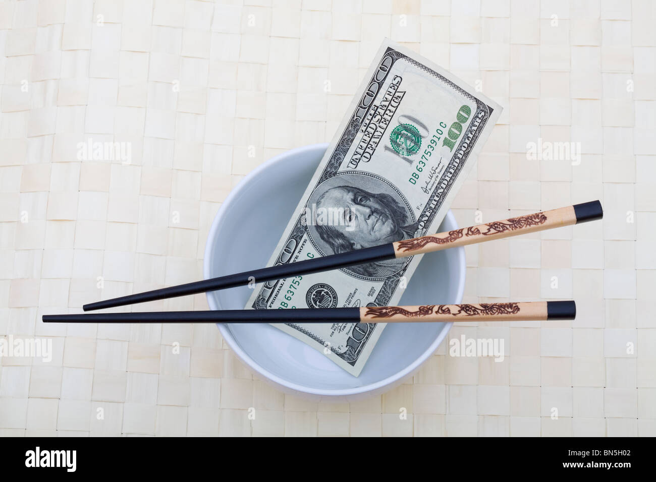 Una ventina di dollari con bacchette e una ciotola Foto Stock