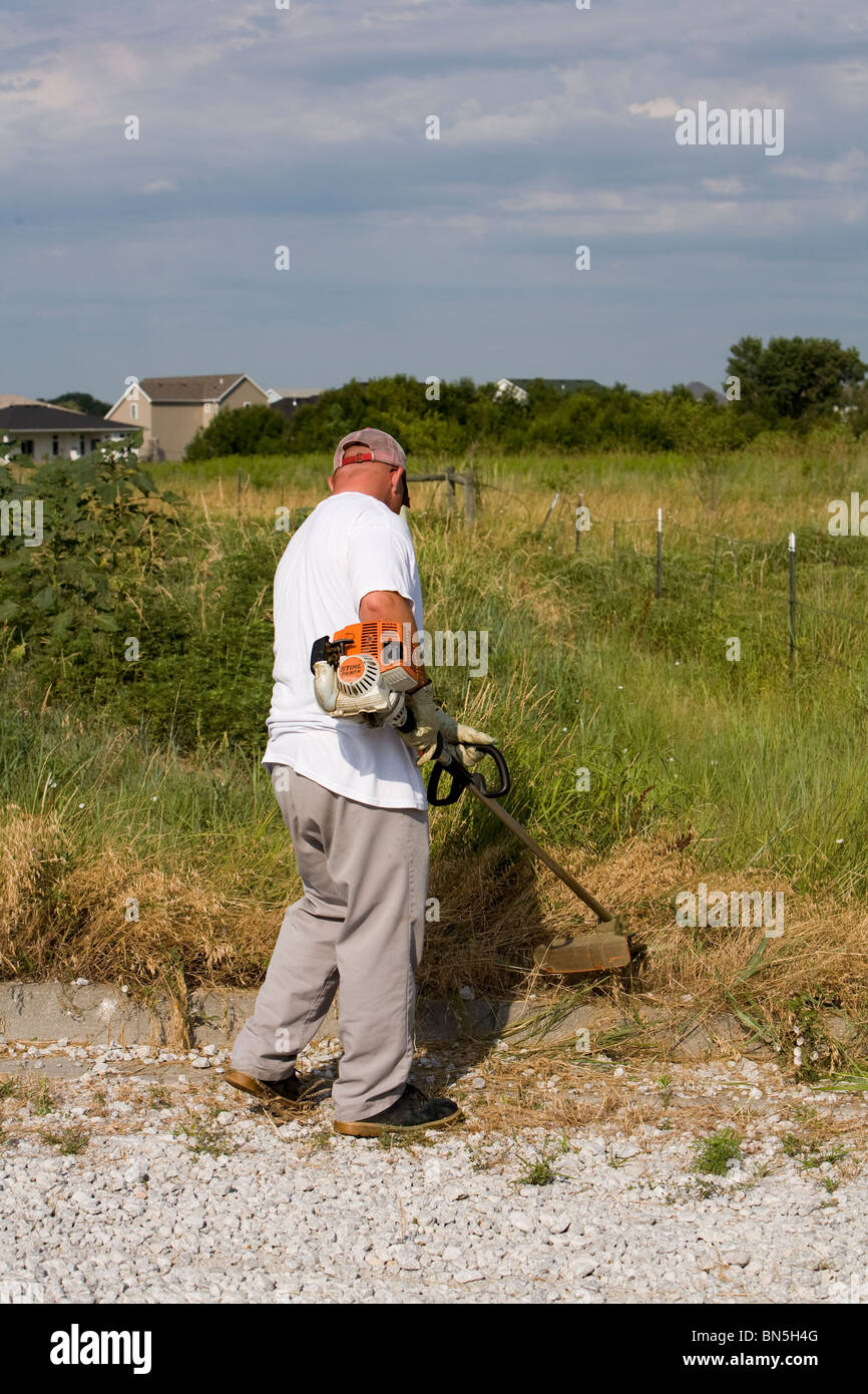 Carcerati lavora sul lato della strada a tagliare erbe infestanti, rivestimento di erba, pick up cestino. Lavoro rilascia, Lincoln, Nebraska, Stati Uniti d'America. Foto Stock