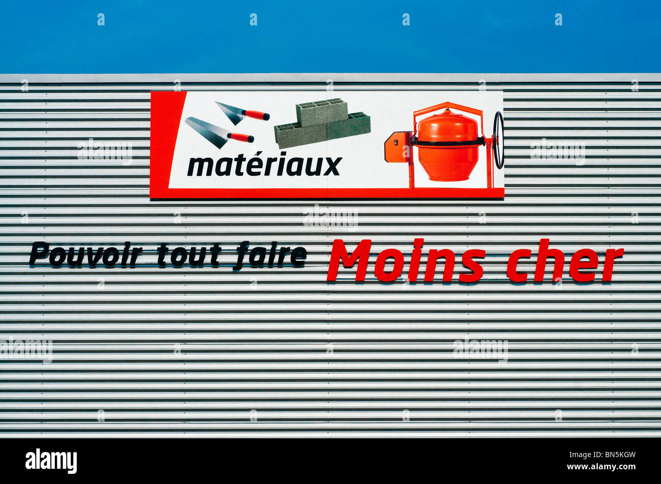 Bricomarché D-I-Y store 'matériaux' e 'moins cher" insegne pubblicitarie, Francia. Foto Stock