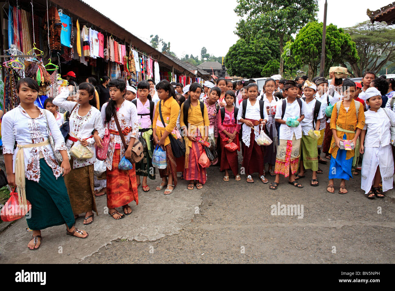 Bambini Balinese andando al tempio. La maggior parte stanno portando un sacco di offerte. Ulun Danu Temple, Beratan, Bali, Indonesia Foto Stock