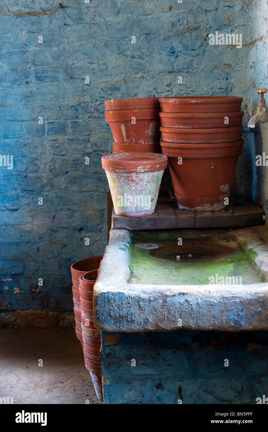 Argilla vasi per piante sorgeva su un vecchio lavandino in pietra in un Potting Shed pronto per la pulizia Foto Stock