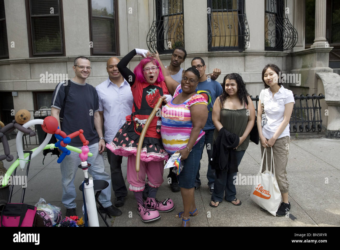 Un gruppo di persone che pongono con un palloncino soffiando clown presso il Gay Pride Festival di Park Slope, Brooklyn, New York. Foto Stock