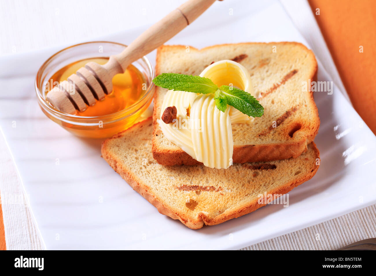 La prima colazione - Fette biscottate, burro e miele Foto stock - Alamy