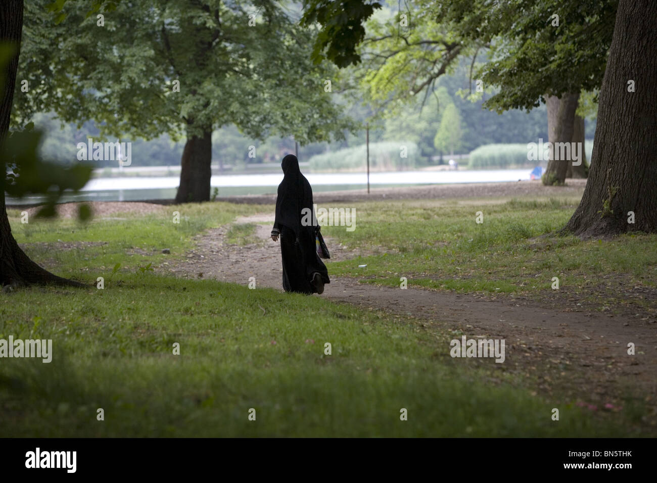 Completamente coperta donna musulmana prende una passeggiata solitaria in Prospect Park di Brooklyn, New York. Foto Stock