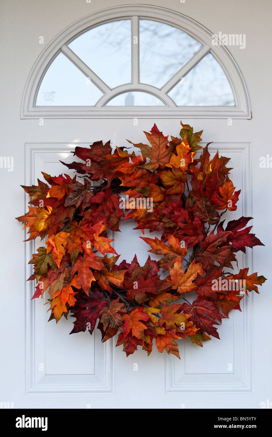 Ghirlanda di foglie autunnali Tempo delle feste primo piano della ghirlanda appesa a una porta bianca d'ingresso immagini immagini vendita su alamy formato verticale negli USA US ad alta risoluzione Foto Stock