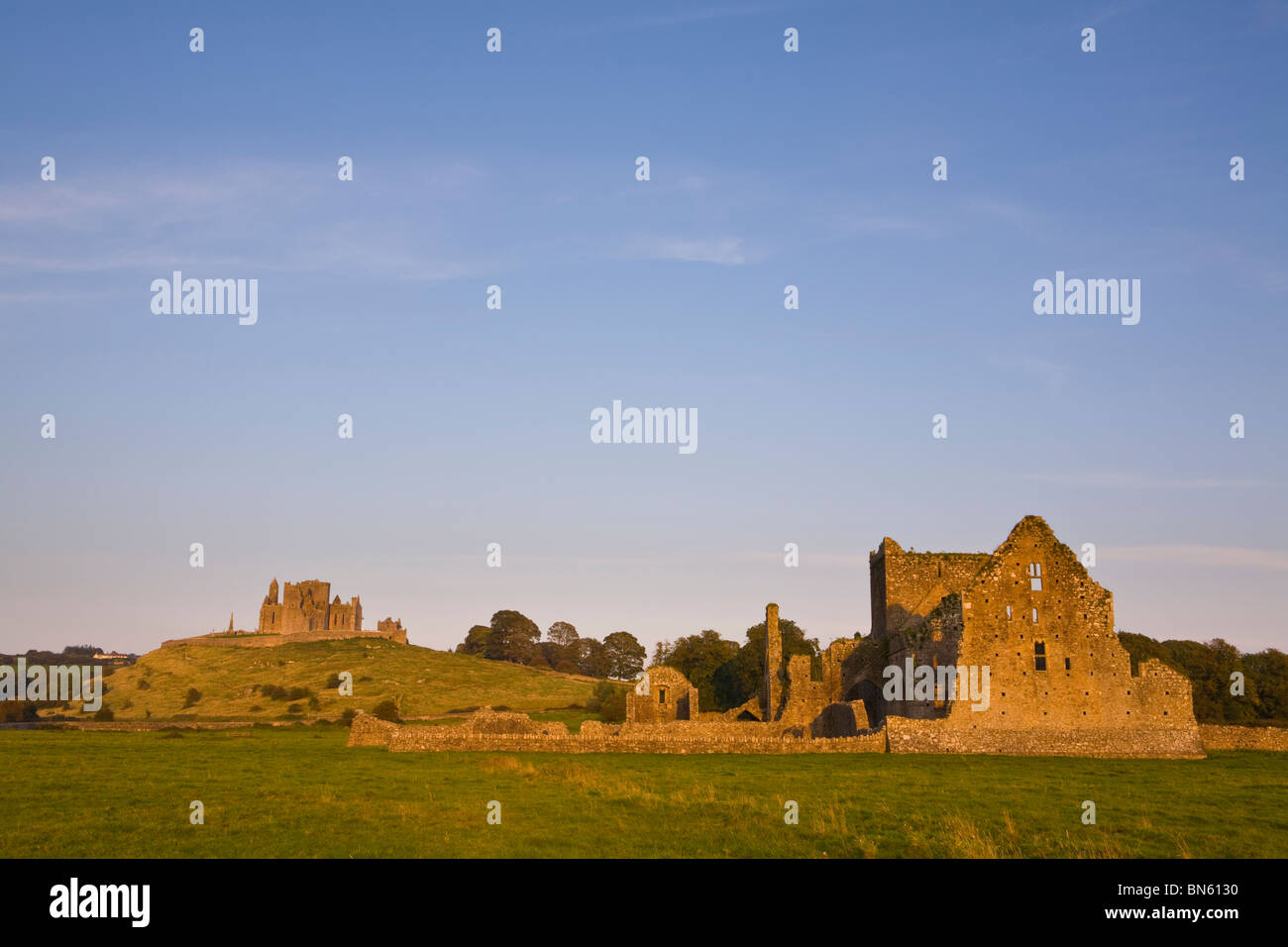 Una luce calda illumina Hore Abbey & la Rocca di Cashel al tramonto, Cashel, Tipperary, minore Shannon, Irlanda Foto Stock