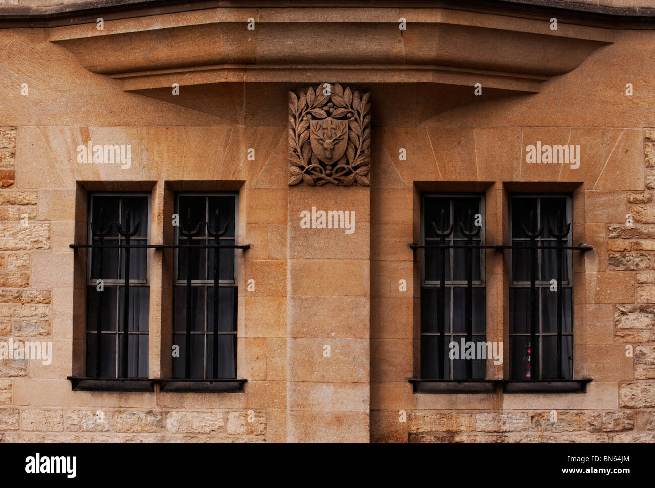 Il scolpito stemma di Hertford College al di sopra di windows in un edificio in pietra arenaria all'Università di Oxford. Foto Stock