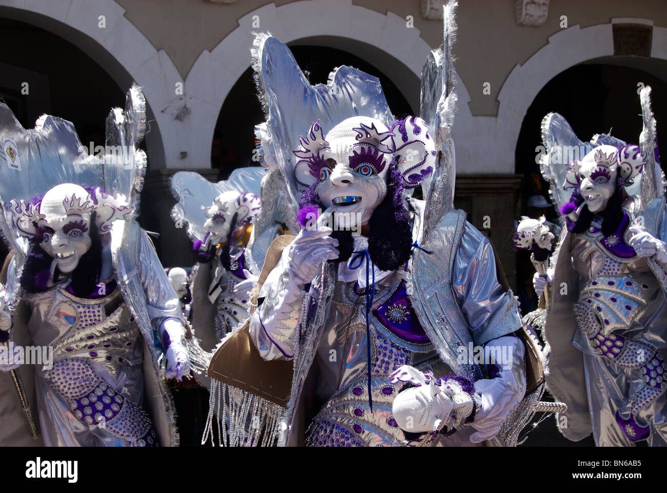 I partecipanti a Oruro carnevale con facce sbiancato e costumi stravaganti Foto Stock