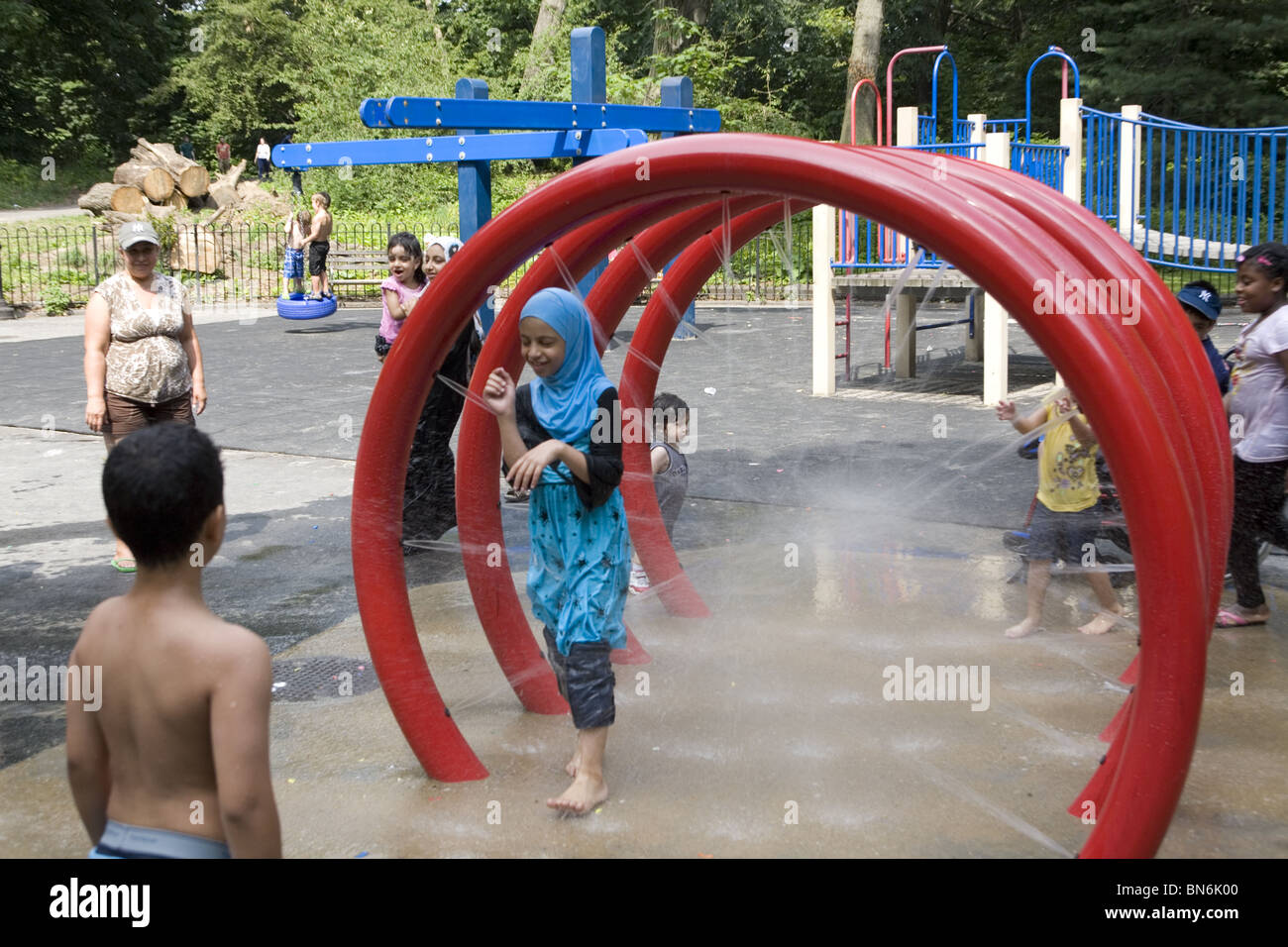 Bambini rinfrescatevi nella zona di acqua in una calda giornata estiva al terzo San parco giochi nel Prospect Park di Brooklyn, New York. Foto Stock
