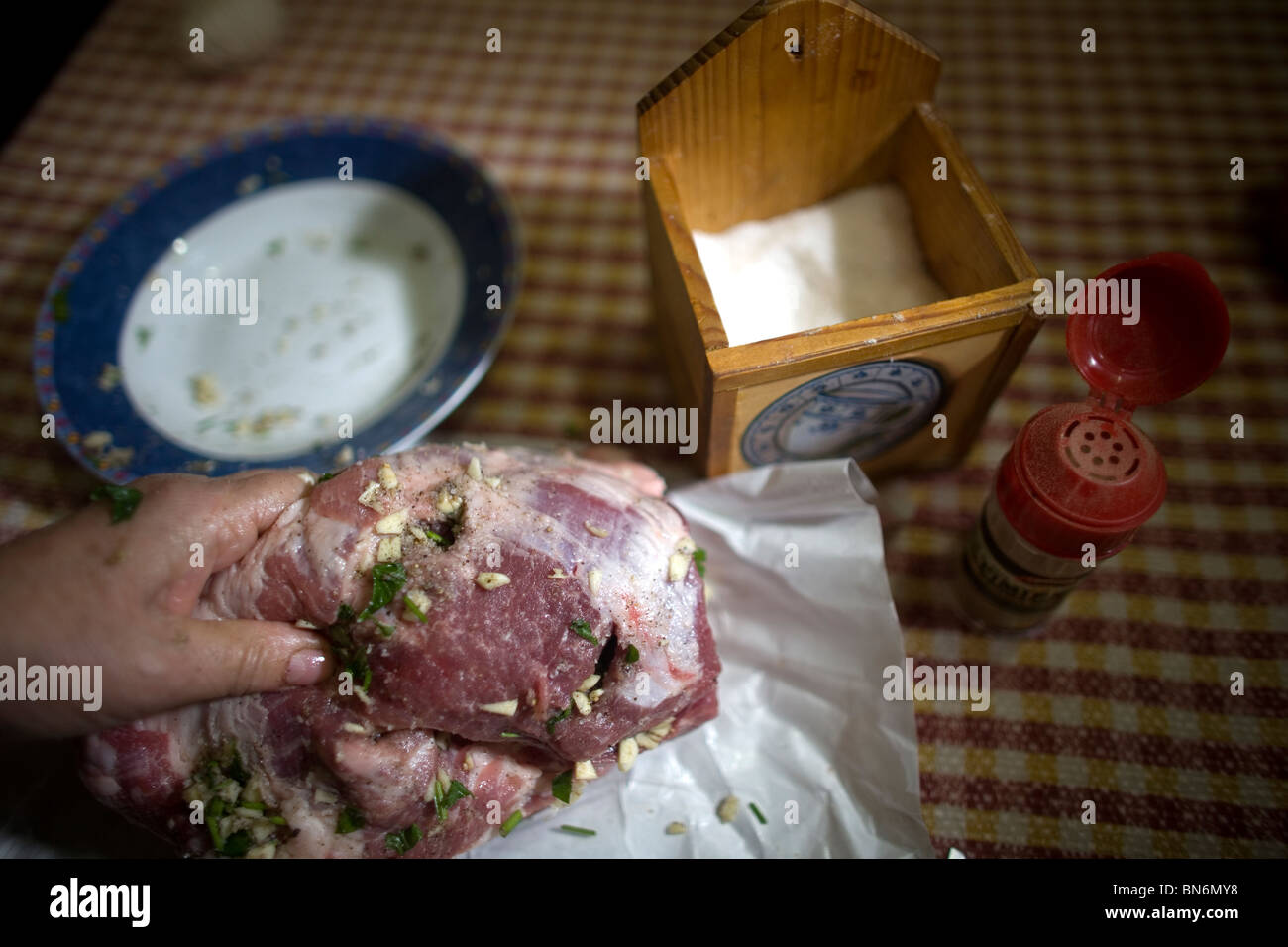 Una donna infila un pezzo di carne da uno spagnolo suino iberico nella sua abitazione a Prado del Rey, Sierra de Cadice, Andalusia, Spagna. Foto Stock