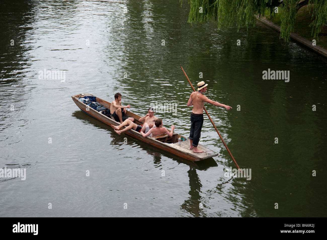 Giovani uomini punting sul fiume Cam Cambridge Regno Unito su estati calde giorno Foto Stock