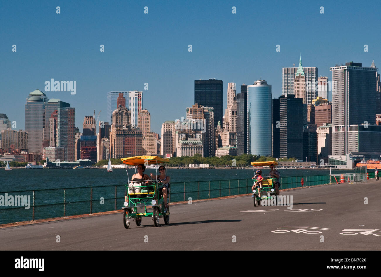 In bicicletta intorno al Governors Island con spettacolari vedute del centro cittadino di Manhattan Foto Stock