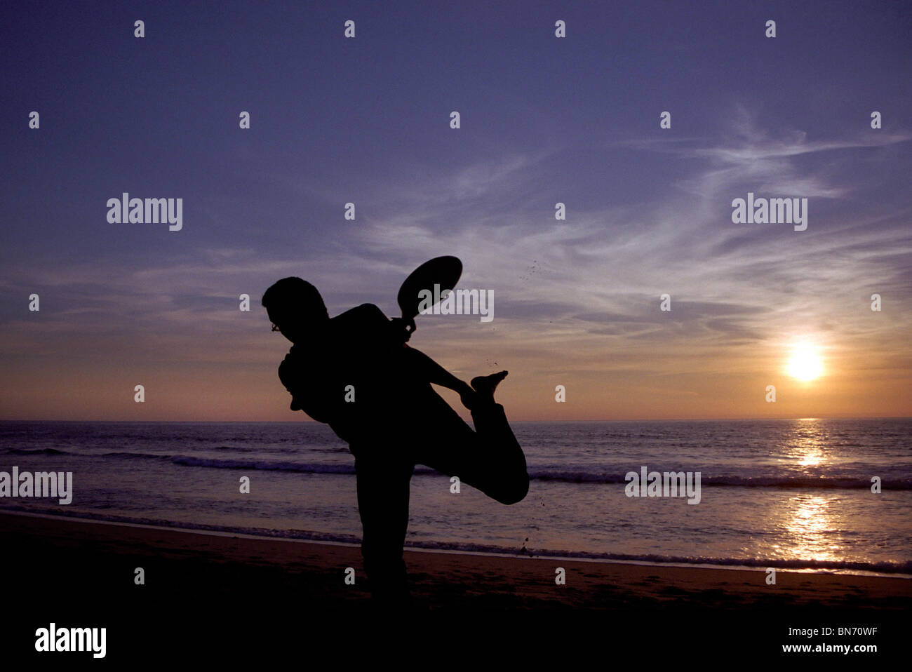 L'uomo gioca racchette sulla spiaggia Foto Stock