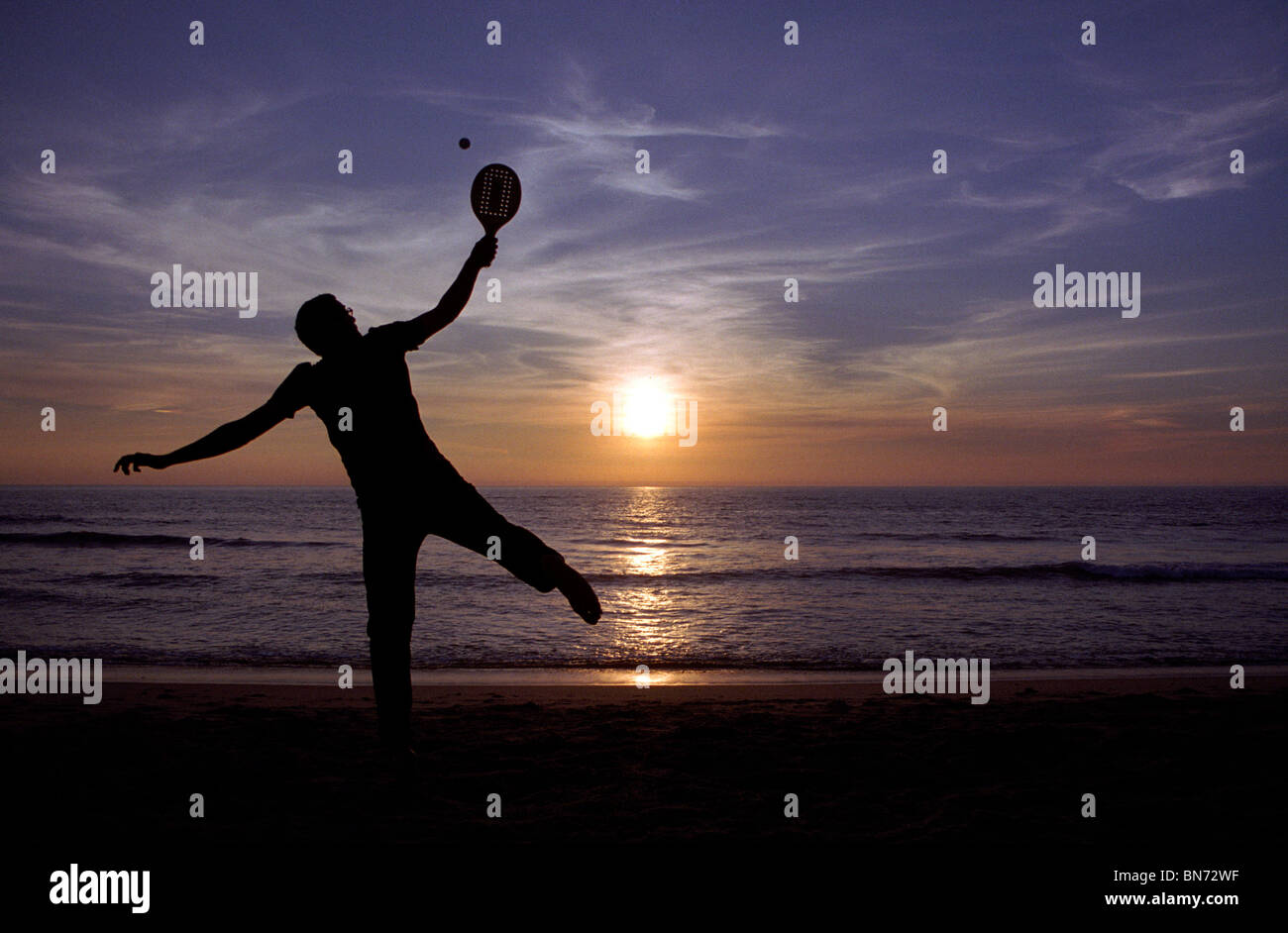 L'uomo gioca racchette sulla spiaggia Foto Stock