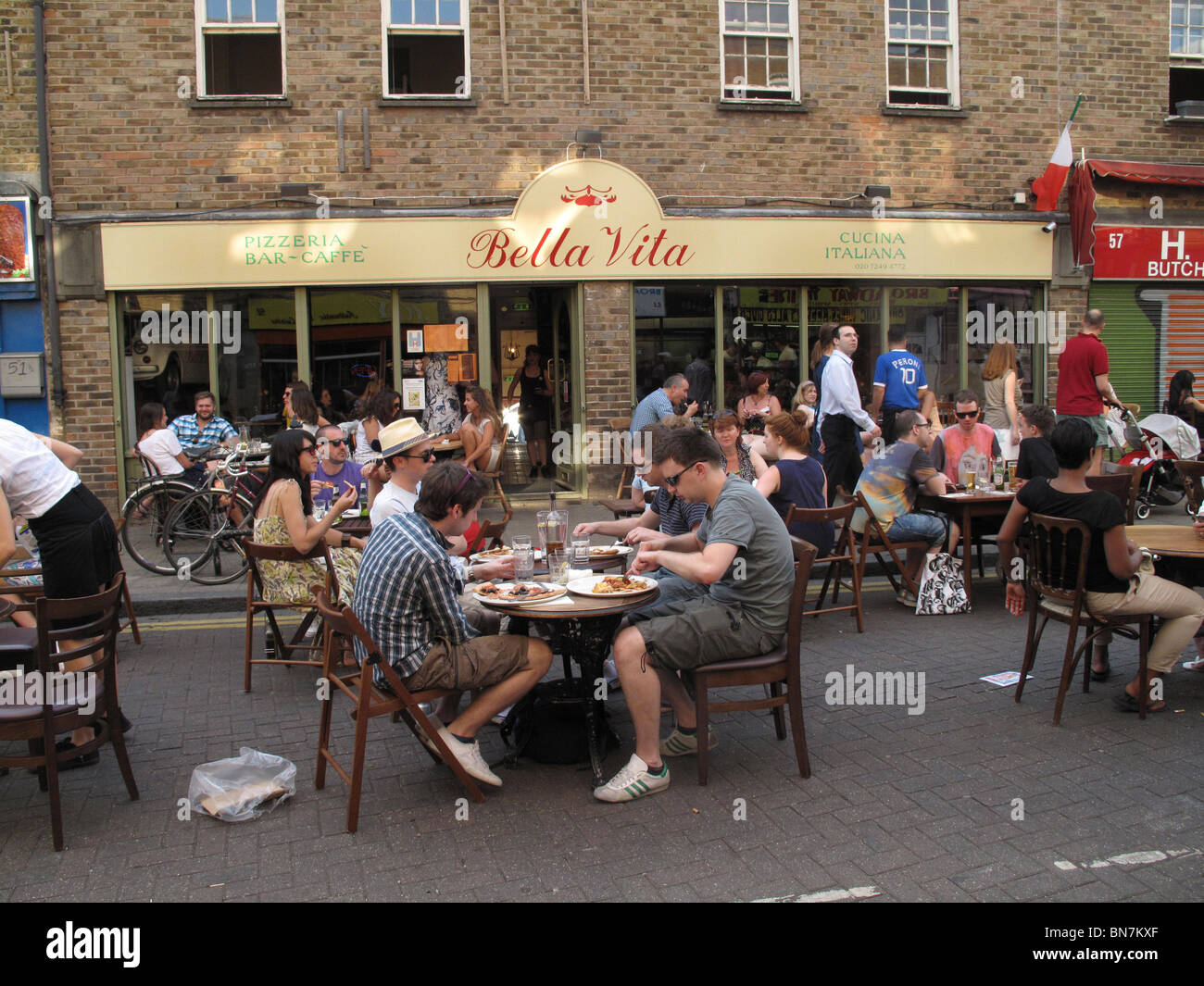 Londra a luglio 2010. Bella Vita cafe Broadway Market con tavoli in strada e i clienti a mangiare la pizza Foto Stock