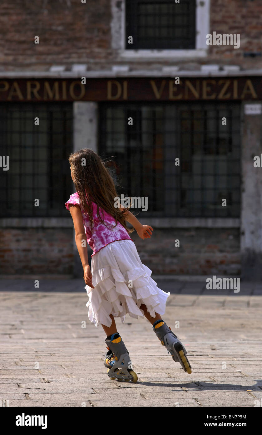 Ragazza italiana che indossa un mantello bianco di pattinaggio a Street su  pattini a rotelle in linea Venezia Italia Foto stock - Alamy