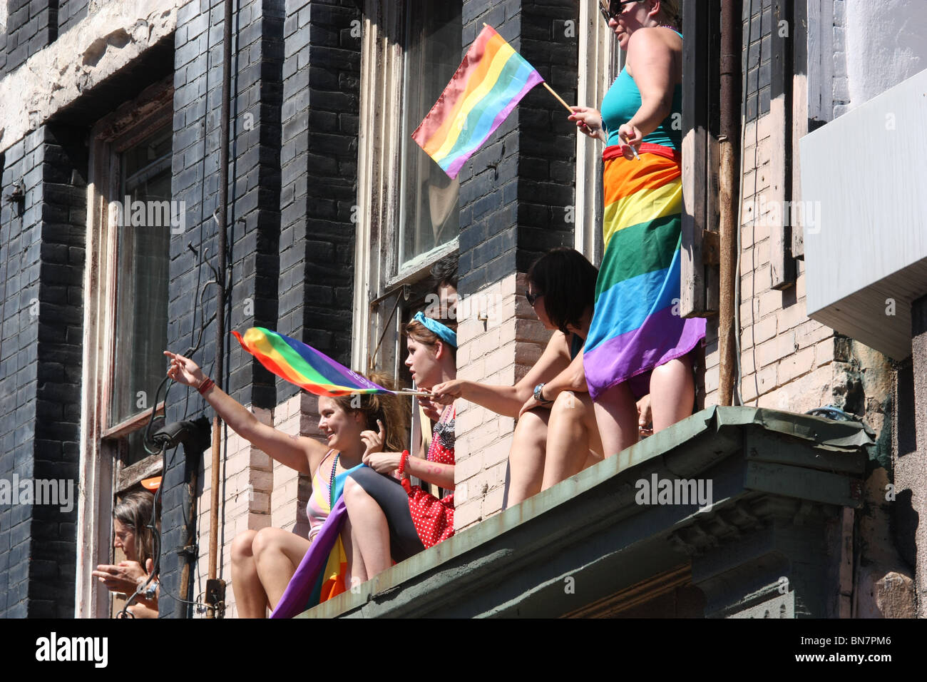 La folla sventola bandiera di orgoglio Foto Stock