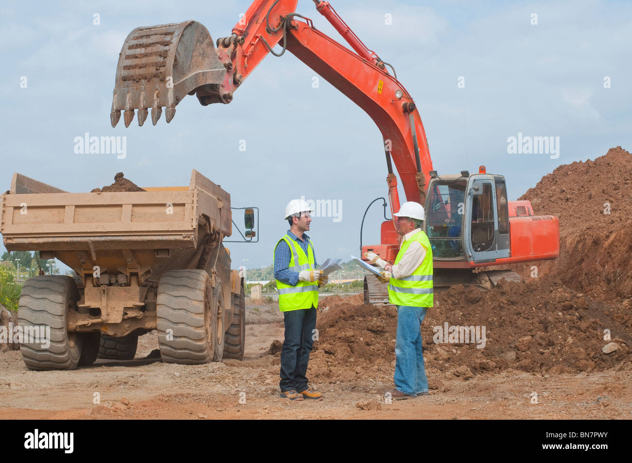 Ispanico lavoratori edili parlando sul sito in costruzione Foto Stock