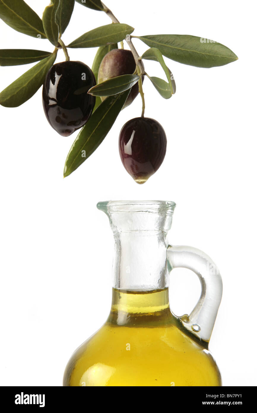 Olive versando olio d'oliva in un vetro può Foto Stock