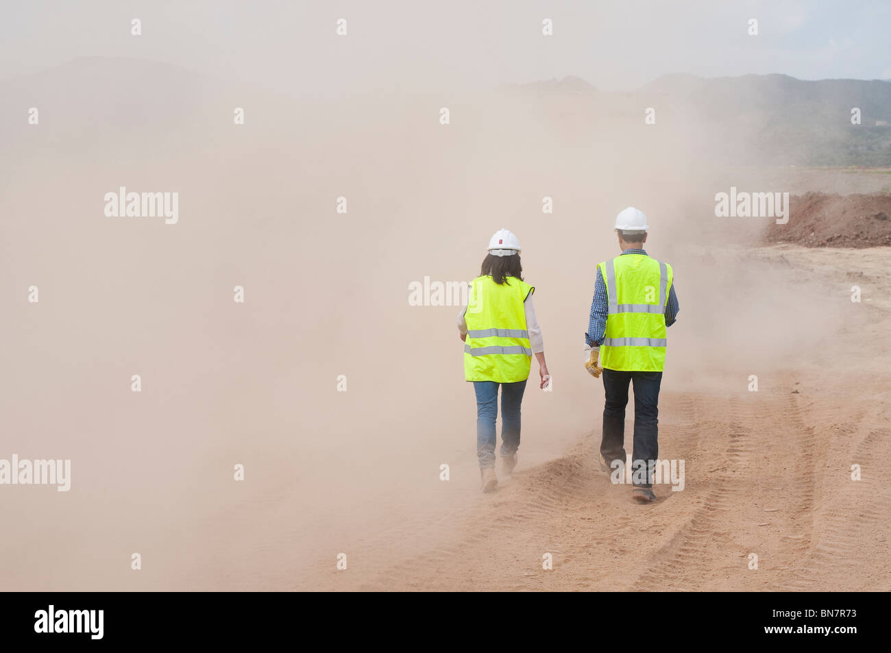 Lavoratori edili a piedi nella nuvola di polvere Foto Stock