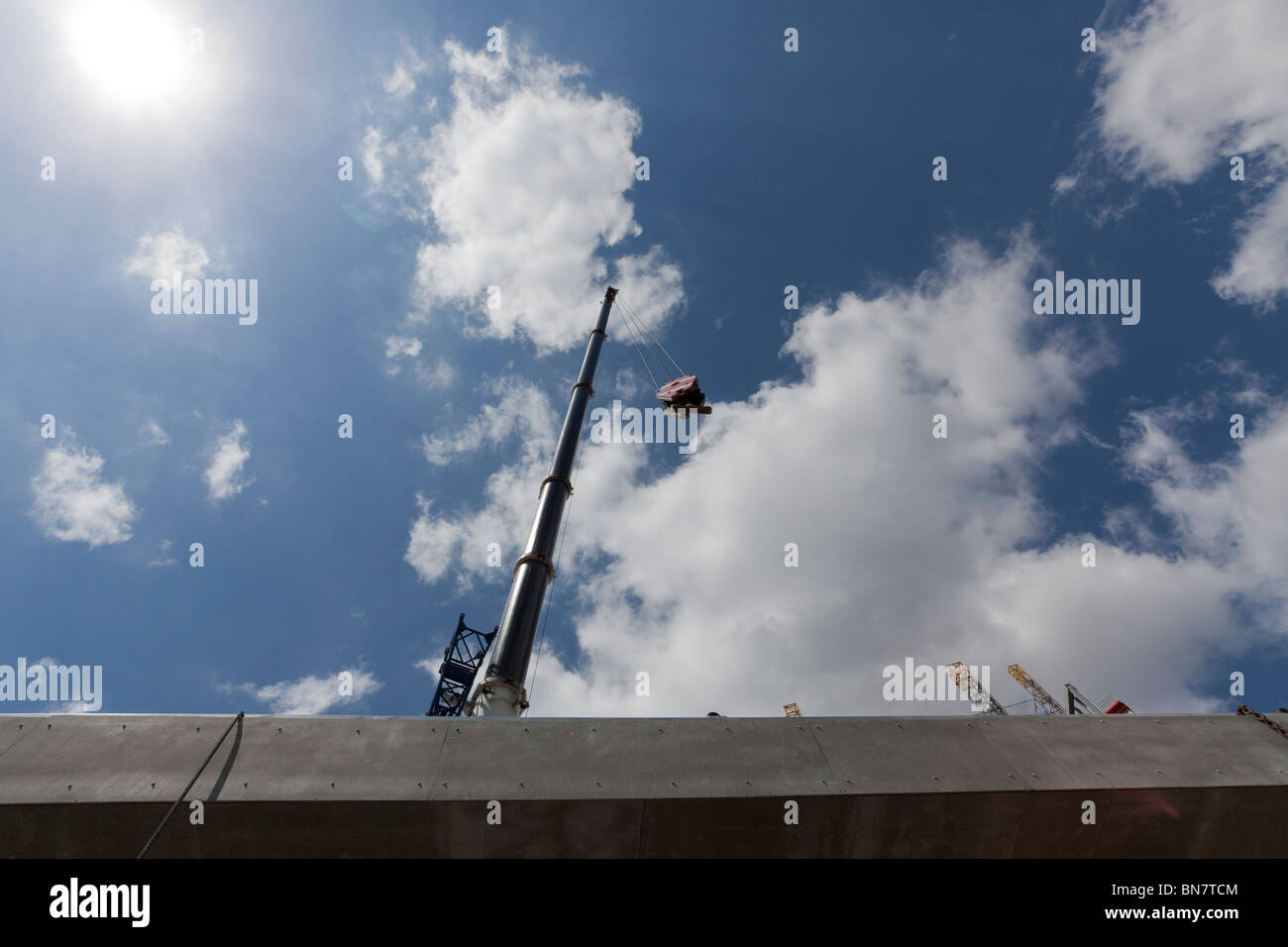 Montante di sollevamento di una gru a gancio contro un cielo blu con nuvole Foto Stock