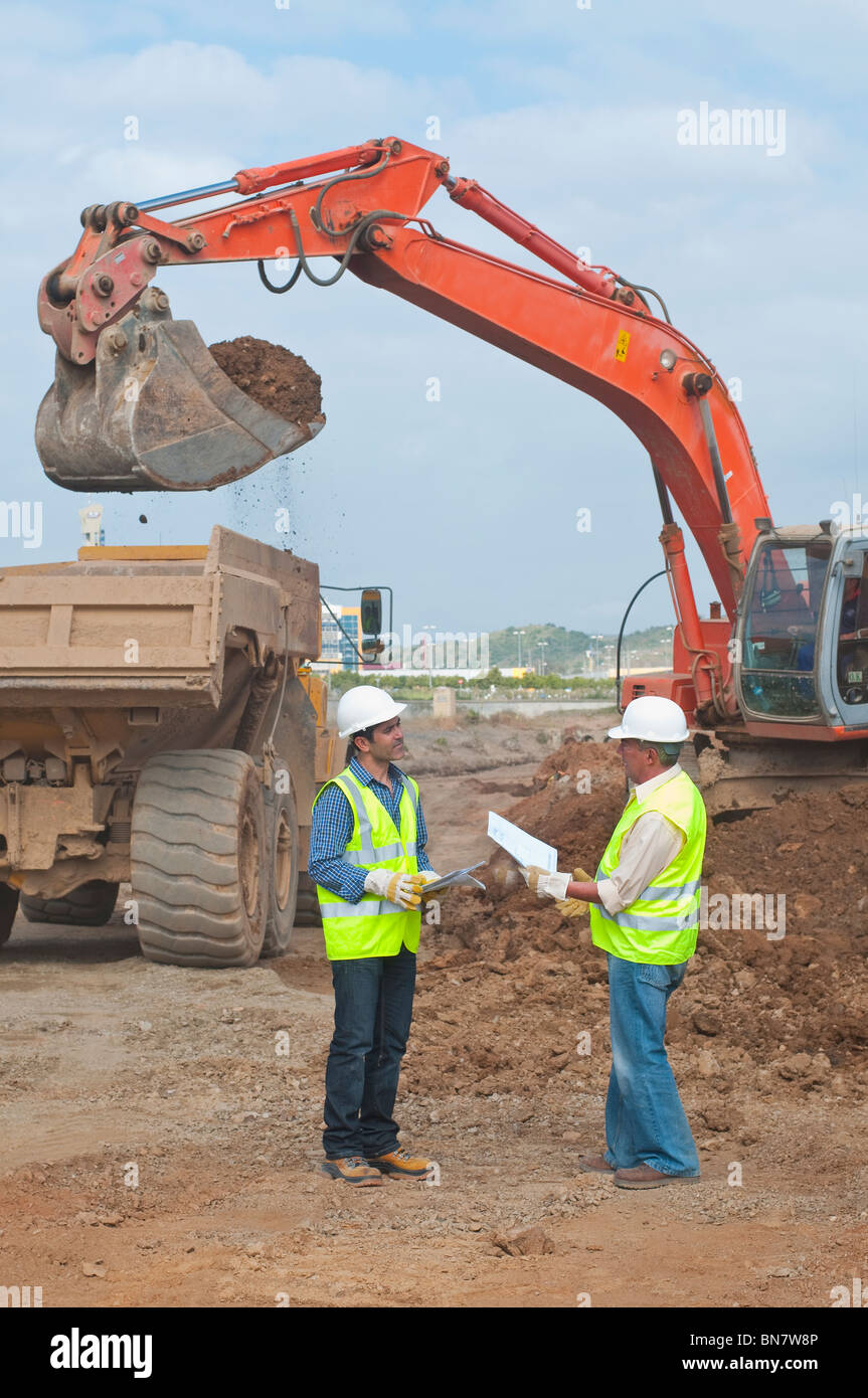 Ispanico lavoratori edili parlando sul sito in costruzione Foto Stock