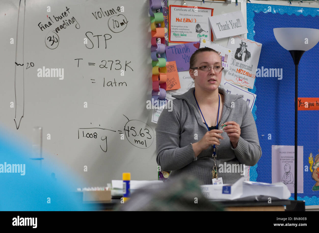 Femmina Anglo high school science insegnante spiega le procedure di esperimento di classe. Foto Stock