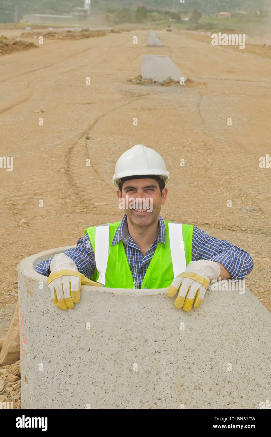 Ispanico lavoratore edile in piedi in tubo di cemento Foto Stock